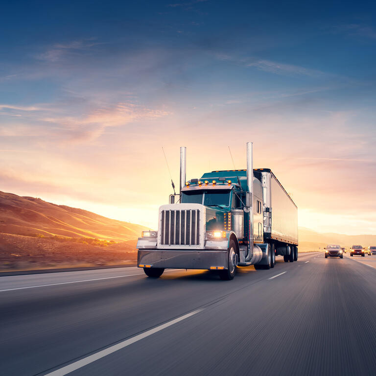 American style truck on freeway pulling load