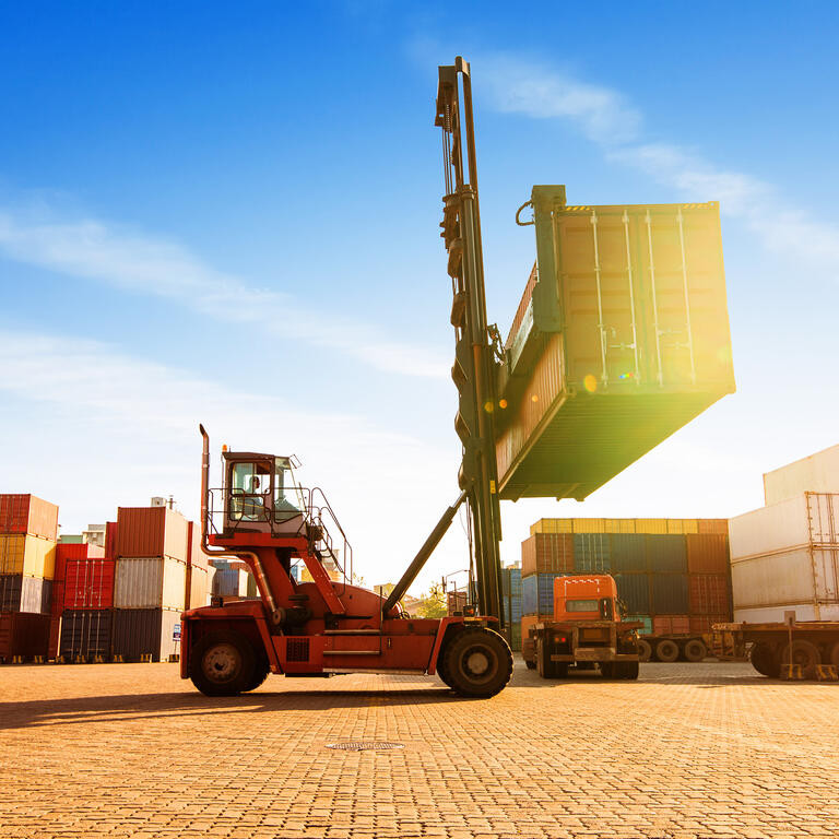 Crane lifting up container in yard