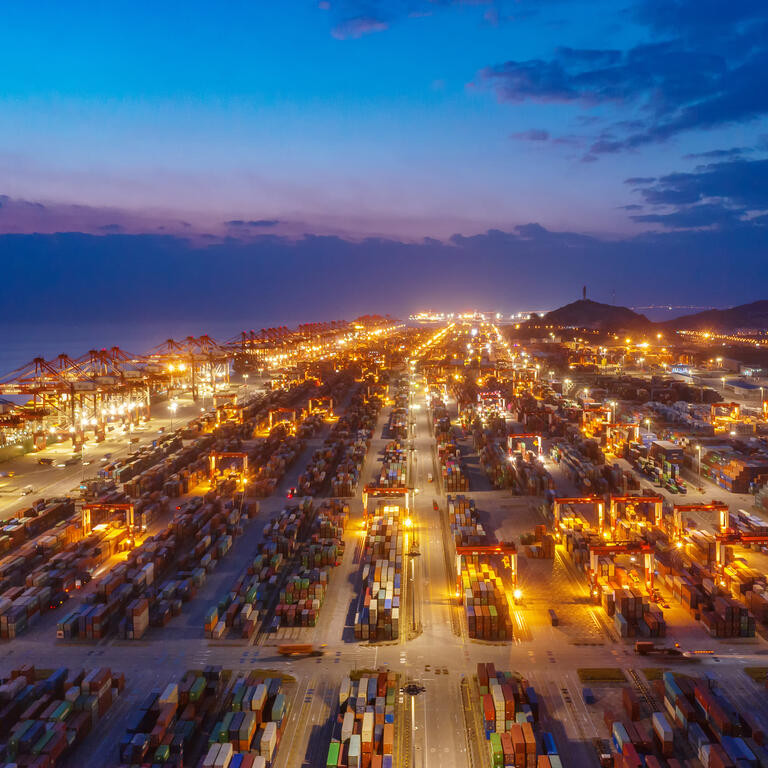 Container ship in export and import business and logistics. Shipping cargo to harbor by crane. Water transport International. Aerial view