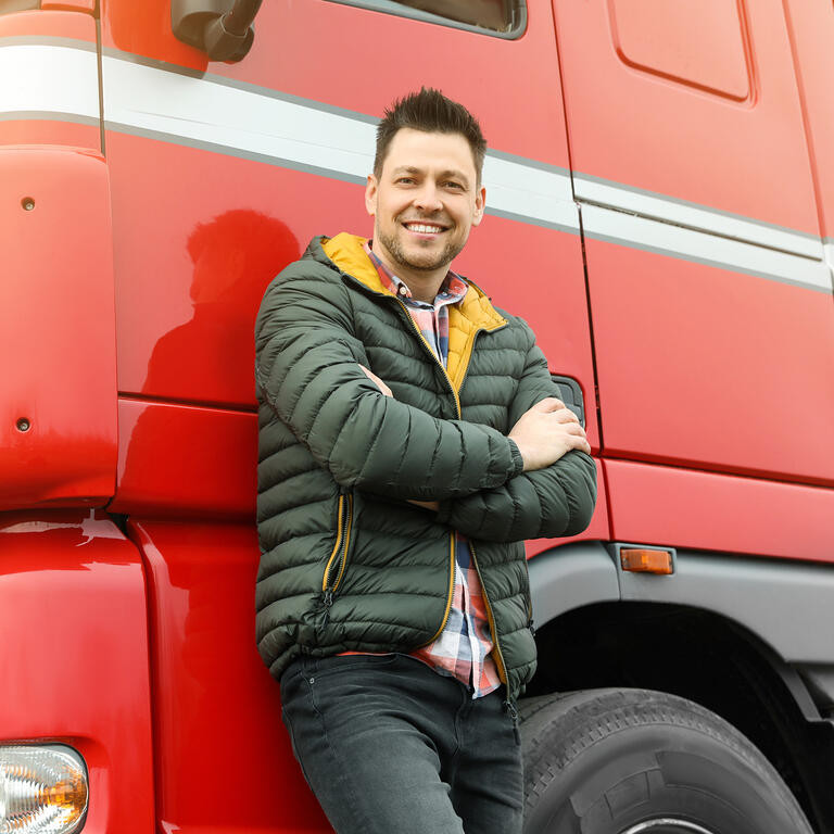 Portrait of happy driver at modern truck outdoors