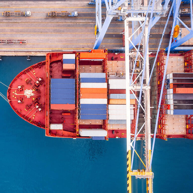 Large container ship loads cargo in logistic port with crane. Concept import export business. Aerial top view