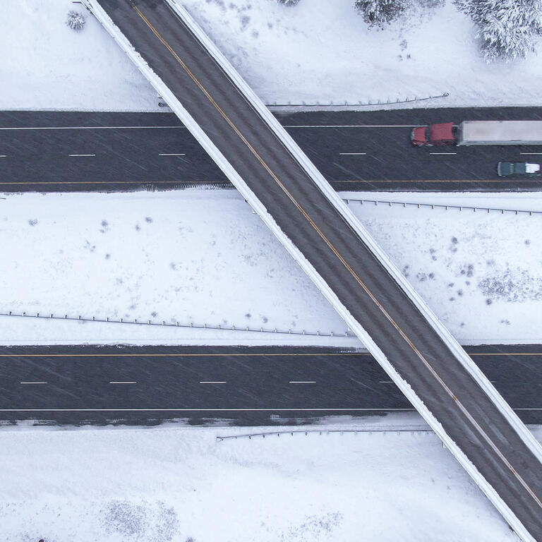 Flying above a highway overpass in USA during an intense blizzard.