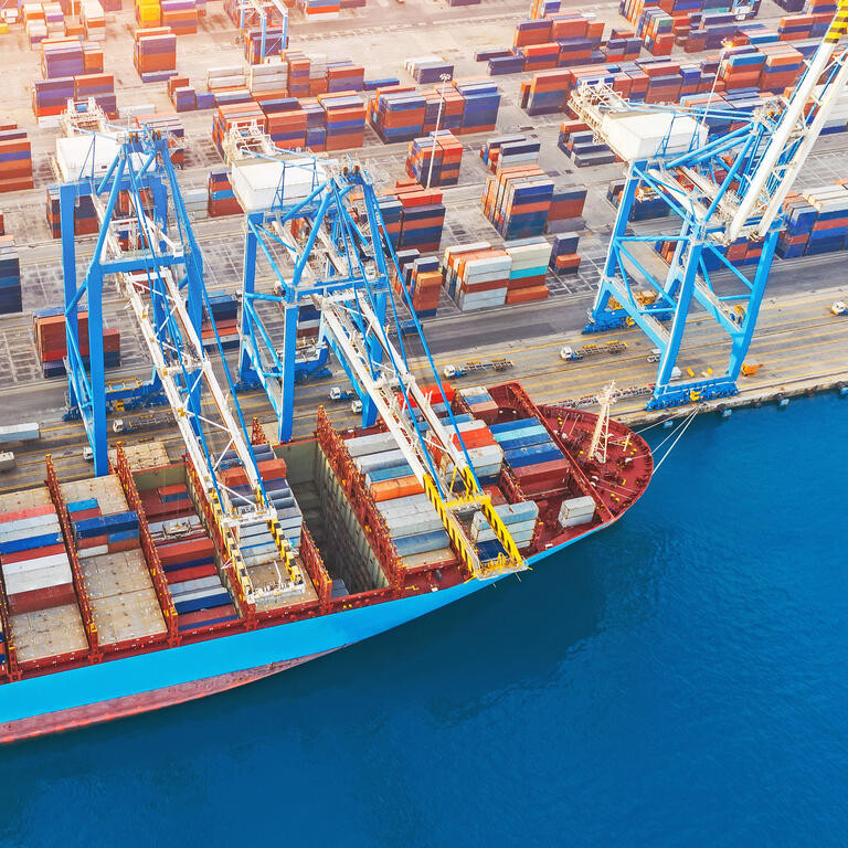 Large container ship in port. front view, unloading loading cargo. Aerial view.