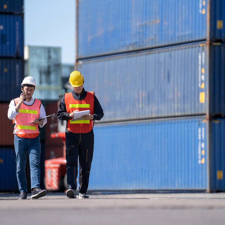 Logistics engineer control at the port, loading containers for trucks export and importing logistic concept